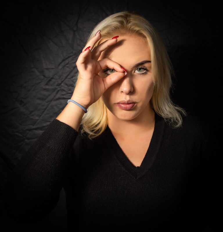 a woman holding her hand over her eye