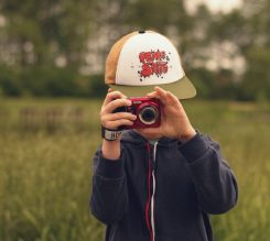 chłopiec wykonuje zdjęcie fotografowi małym czerwonym aparatem cyfrowym