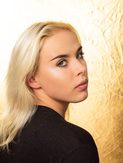 a woman looking back with blonde hair